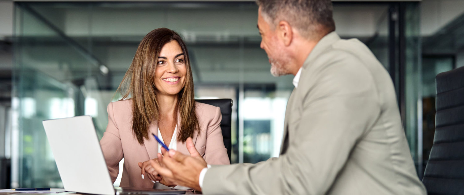 Happy professional mature executive colleagues at corporate meeting in office.