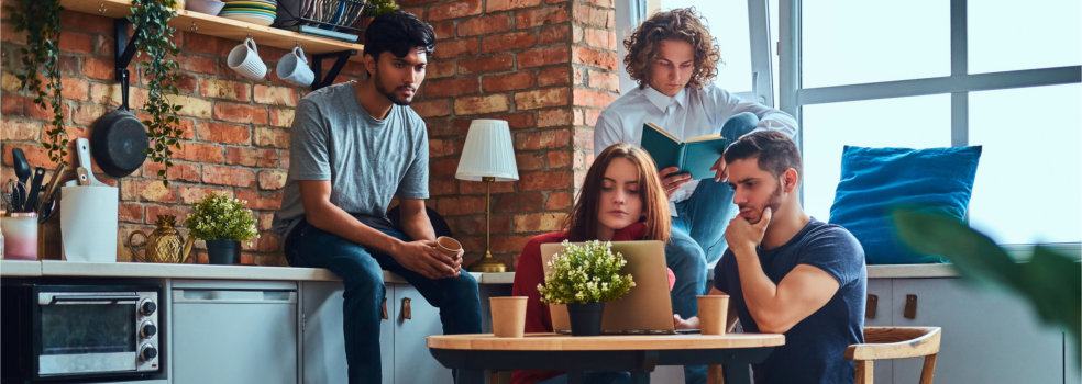 Kitchen in student dormitory. Group of interracial students engaged in education.